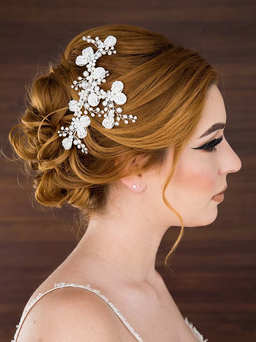Model wearing white wedding dress and floral hairclip