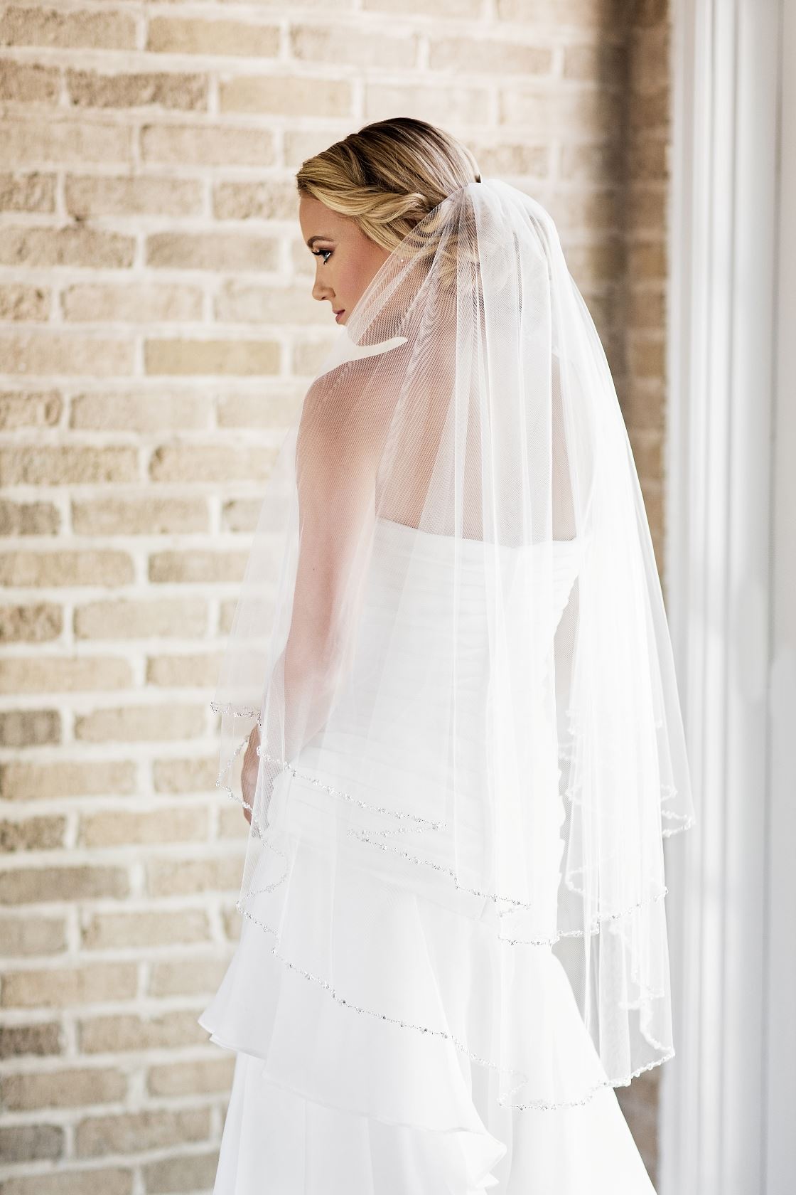 Model wearing white wedding dress and veil